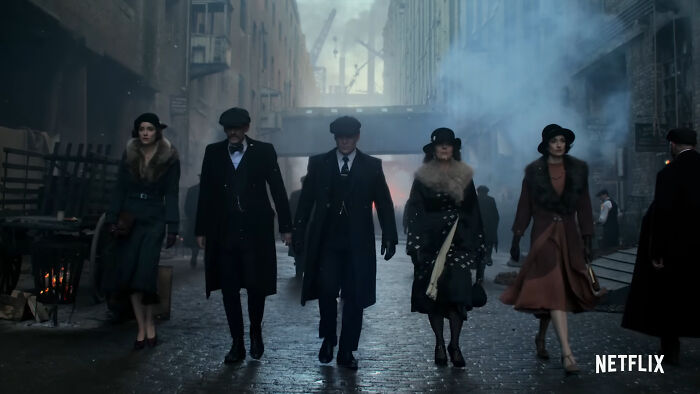 Group of five characters walking in a foggy, historic alleyway from one of the best Netflix shows praised by netizens.