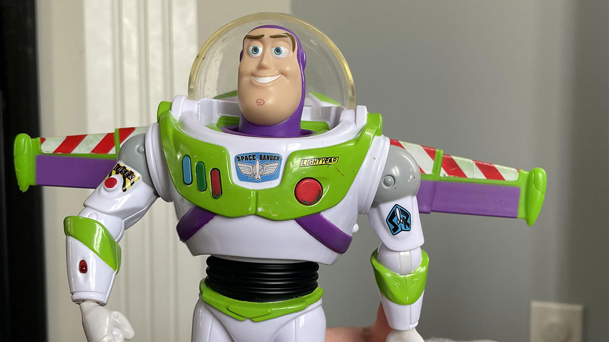 Buzz Lightyear toy figure with green and white spacesuit held in indoor setting, medical professionals amazed items found