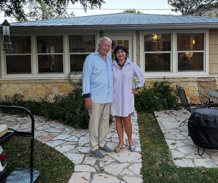 Older couple standing outside a house with a stone patio, related to sisters found with hands locked together in Texas floods. Older couple standing outside a house with a stone patio, related to sisters found with hands locked together in Texas floods.