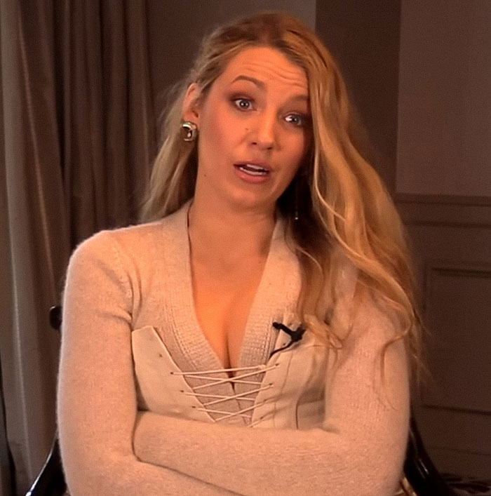 Blake Lively wearing a beige top and speaking during an interview with a serious expression indoors. Blake Lively wearing a beige top and speaking during an interview with a serious expression indoors.