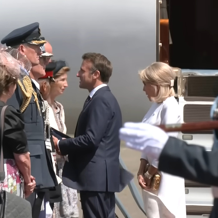 Brigitte Macron standing apart with cold behavior while husband Emmanuel Macron greets officials during UK visit. Brigitte Macron standing apart with cold behavior while husband Emmanuel Macron greets officials during UK visit.