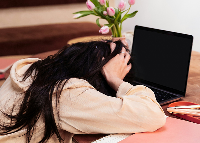 Stressed woman with long hair frustrated by data issues, sitting at a desk with laptop and notebook. Stressed woman with long hair frustrated by data issues, sitting at a desk with laptop and notebook.