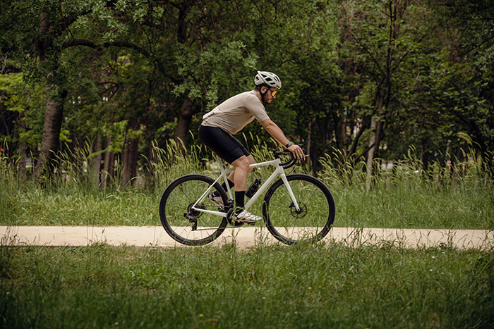 Man cycling on a path in a park wearing helmet and sportswear, choosing a cycle trip over family plans. Man cycling on a path in a park wearing helmet and sportswear, choosing a cycle trip over family plans.