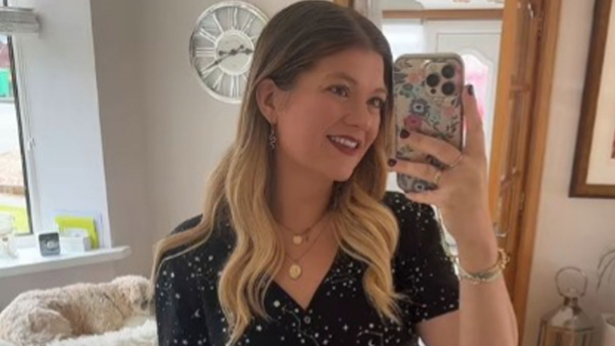 Young woman taking a selfie in a mirror, showcasing the breakup glow-up effect with styled hair and a confident smile.