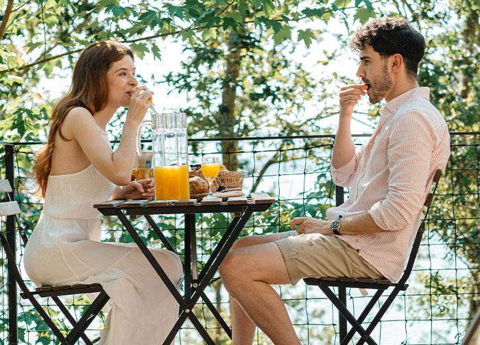 A man and woman having a candid outdoor conversation over breakfast, reflecting men get brutally honest moments.