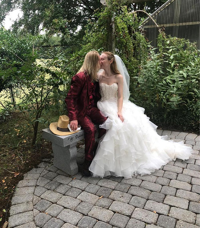 Couple in wedding attire sitting on a bench outdoors, unrelated to Virginia councilman set on fire attack news. Couple in wedding attire sitting on a bench outdoors, unrelated to Virginia councilman set on fire attack news.