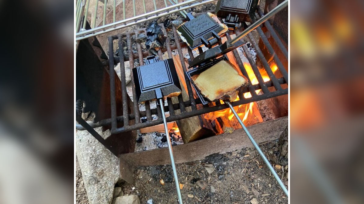 Campfire cooking with camping hacks using sandwich makers on grill over open fire in the great outdoors.
