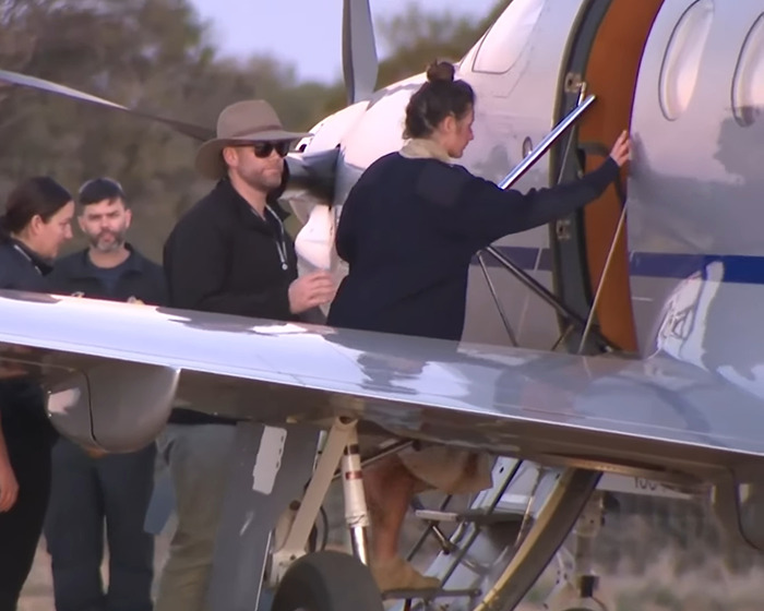 Backpacker found after going missing in Australian outback, boarding a small aircraft with support team nearby. Backpacker found after going missing in Australian outback, boarding a small aircraft with support team nearby.