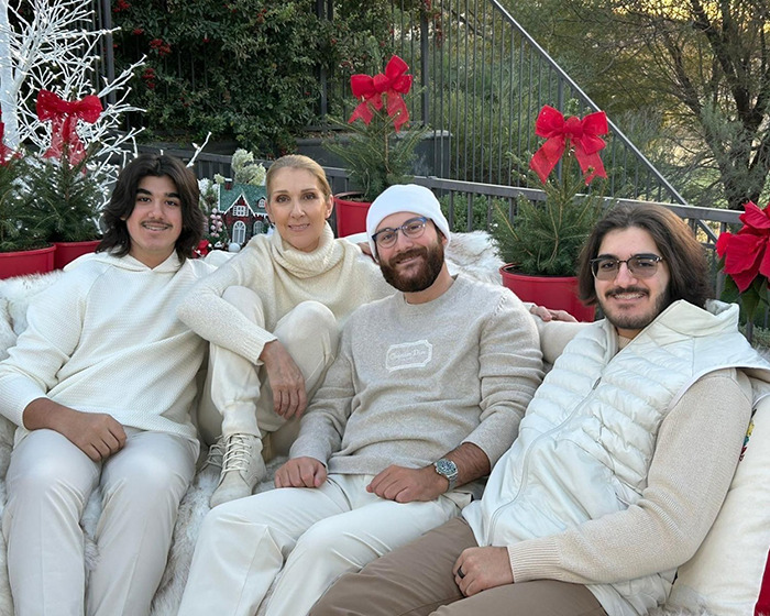 Céline Dion with family outdoors during holiday season, surrounded by festive decorations and red bows. Céline Dion with family outdoors during holiday season, surrounded by festive decorations and red bows.