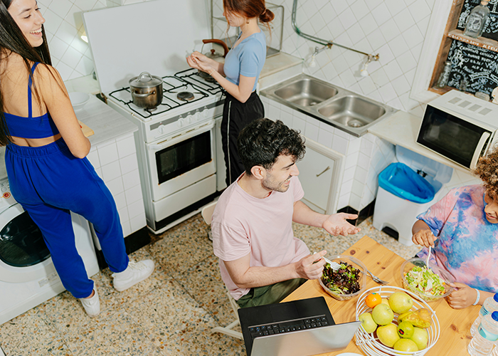 College students cleaning and eating together in a kitchen, encouraged by their only female roommate being petty. College students cleaning and eating together in a kitchen, encouraged by their only female roommate being petty.