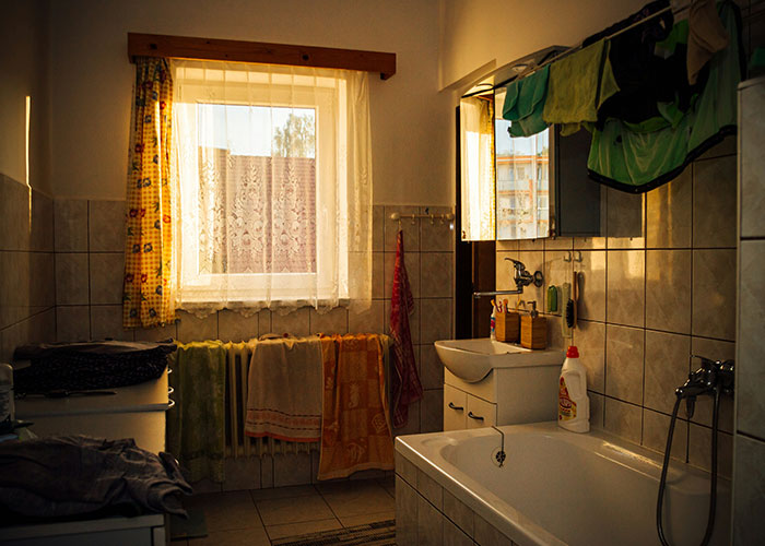 College students bathroom with towels hanging and sunlight coming through window showing tidy shared space. College students bathroom with towels hanging and sunlight coming through window showing tidy shared space.