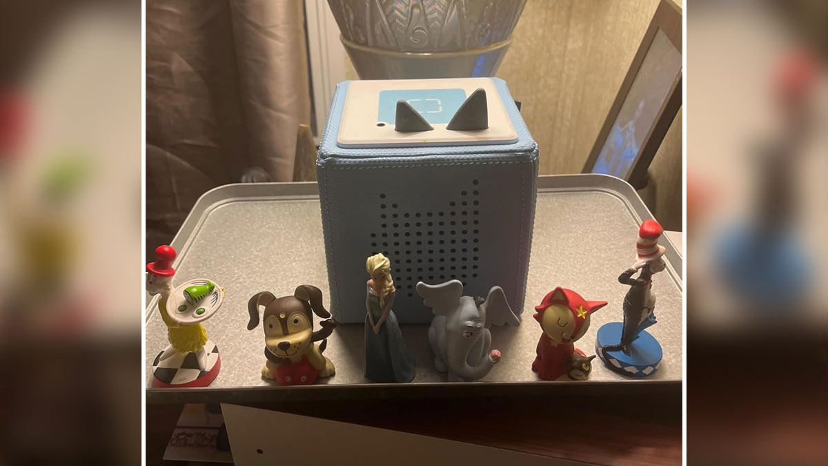 Blue speaker cube with cat ears surrounded by small colorful collectible figurines on a table, Prime Day treasures display.