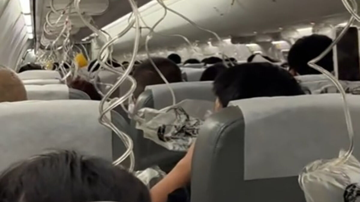 Passengers inside a Japan Airlines flight during an emergency oxygen mask deployment after sudden mid-air plunge.