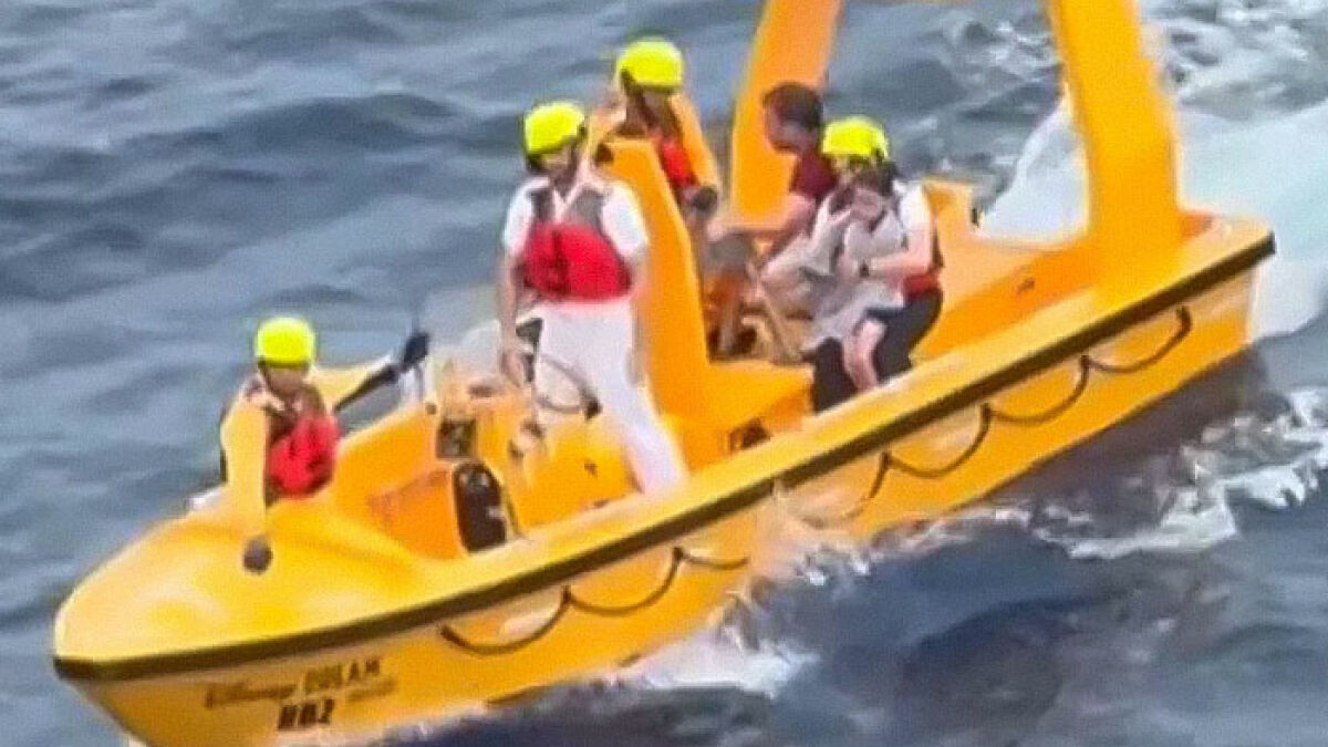 Rescue team in yellow helmets on a bright yellow vessel searching waters after girl's fall from Disney cruise ship incident.