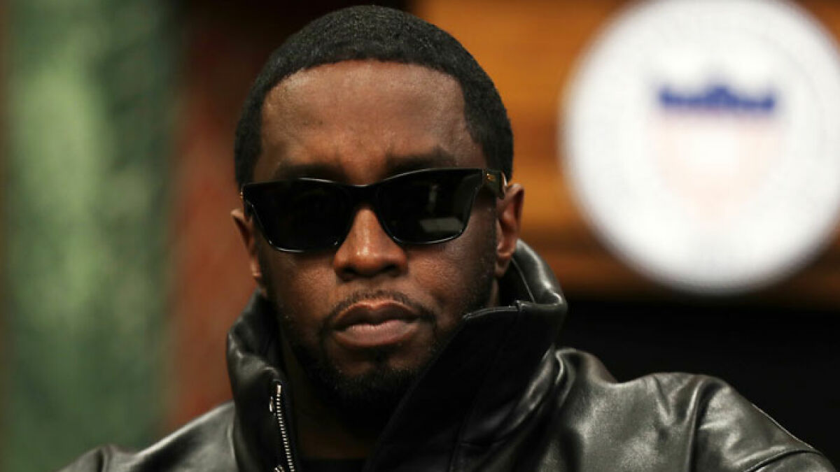 Diddy wearing sunglasses and a black leather jacket during trial proceedings in a courtroom setting