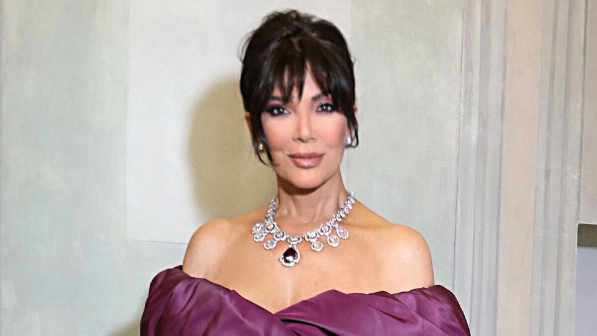 Kris Jenner posing in elegant purple dress and statement necklace amid skeleton Barbie leg Photoshop controversy.