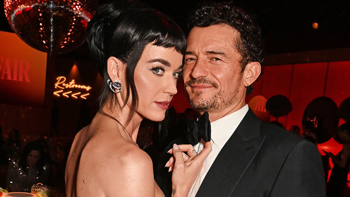 Katy Perry and Orlando Bloom posing together at an event, highlighting their relationship after breakup news.