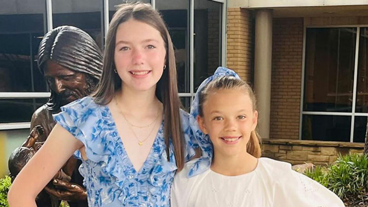 Two sisters smiling outside, representing sisters who lost their lives in Texas floods with hands locked together.