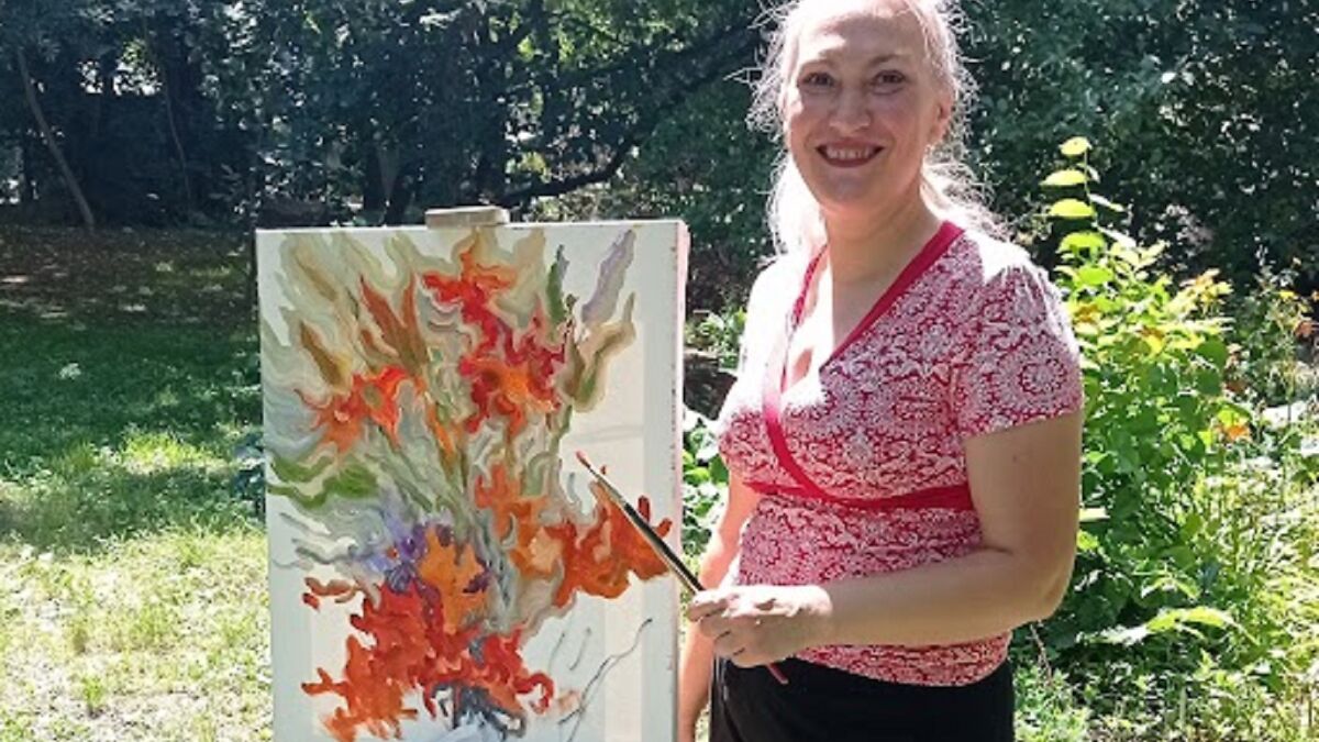 Woman painting vibrant lilies on canvas outdoors in a garden, enjoying the process of drawing flowers.