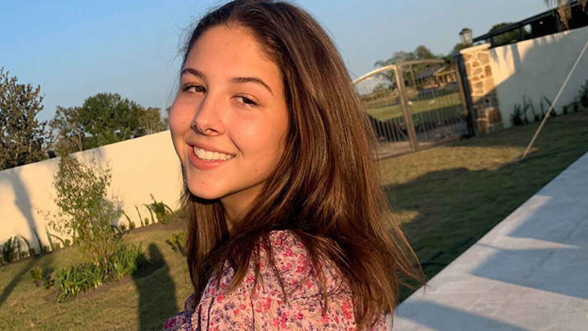 Young flood victim smiling outdoors in a garden setting, capturing the emotional impact of the flooding disaster.