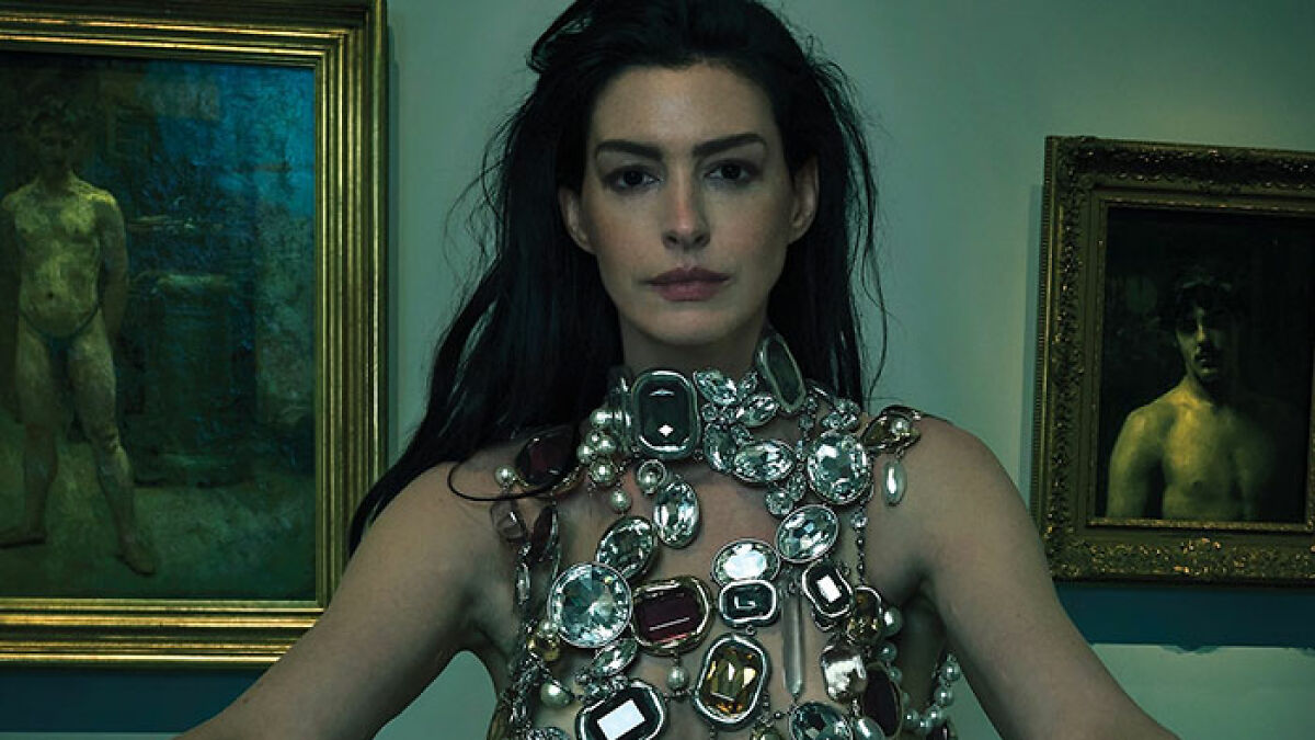 Anne Hathaway wearing a statement jeweled outfit in a Vogue photoshoot amid fan backlash and outrage over the cover design.