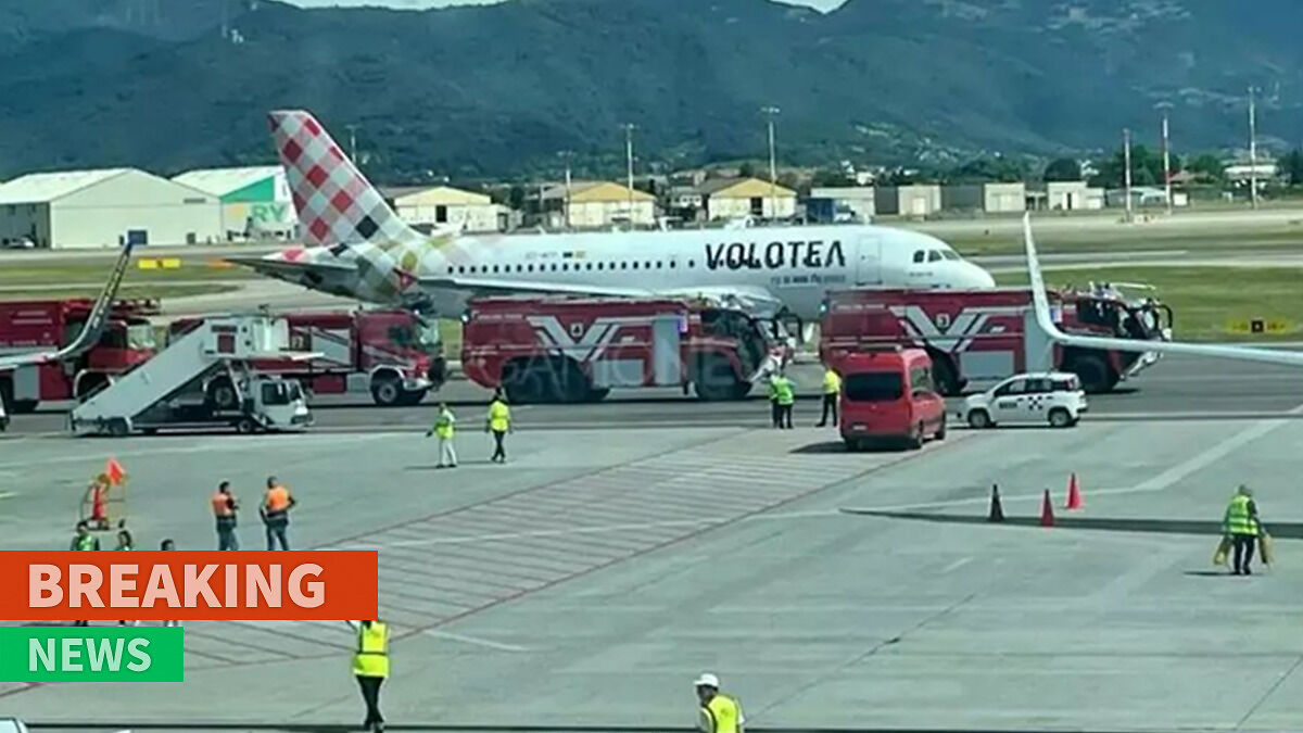 Airport emergency vehicles and staff responding to an incident near a plane engine on the runway.