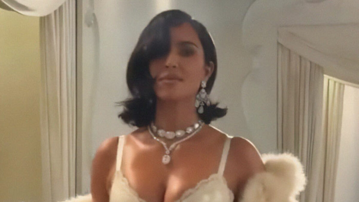 Kim Kardashian wearing elegant jewelry and cream outfit, facing camera after runway walk at Paris Fashion Week 2025.