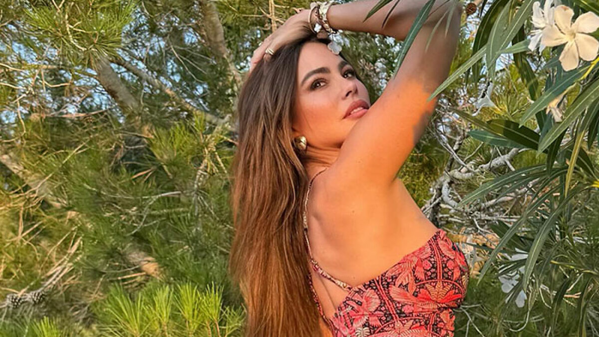 Sofu00eda Vergara posing outdoors in a colorful summer dress, capturing the essence of summer romance and spice.