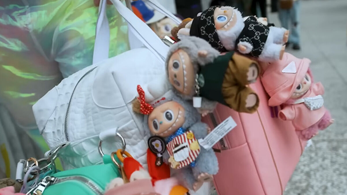 Plush Labubu toys attached to colorful bags, highlighting concerns around City bans and dark conspiracy fears.