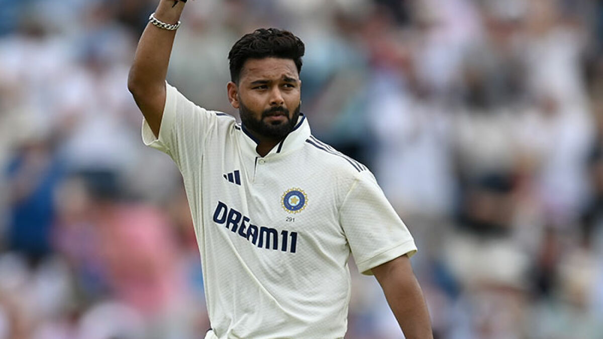 Top athlete in cricket whites raising hand on field during a match, highlighting athlete interaction and Wimbledon event.