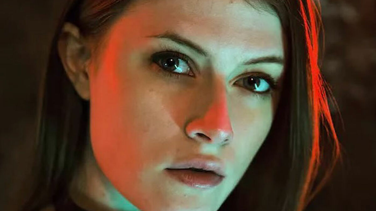 Close-up of a professional escort's face with dramatic lighting highlighting racial discrimination in the industry debate.