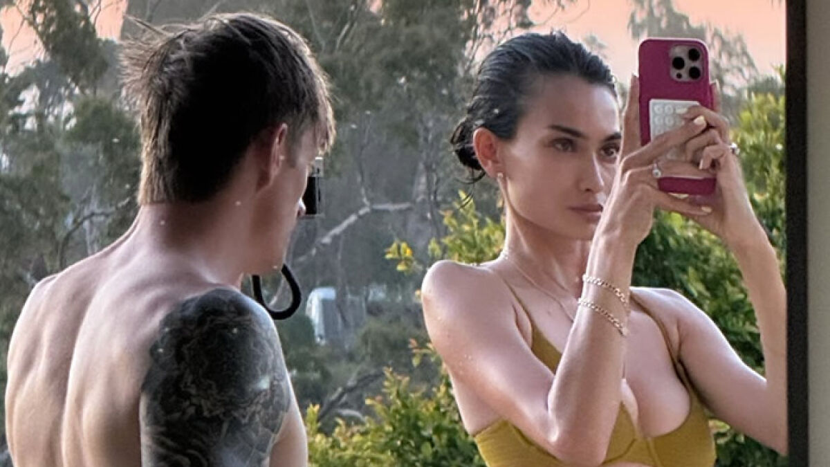 Kelly Gale taking a selfie in a bikini outdoors with a man nearby, highlighting a major Photoshop blunder controversy.