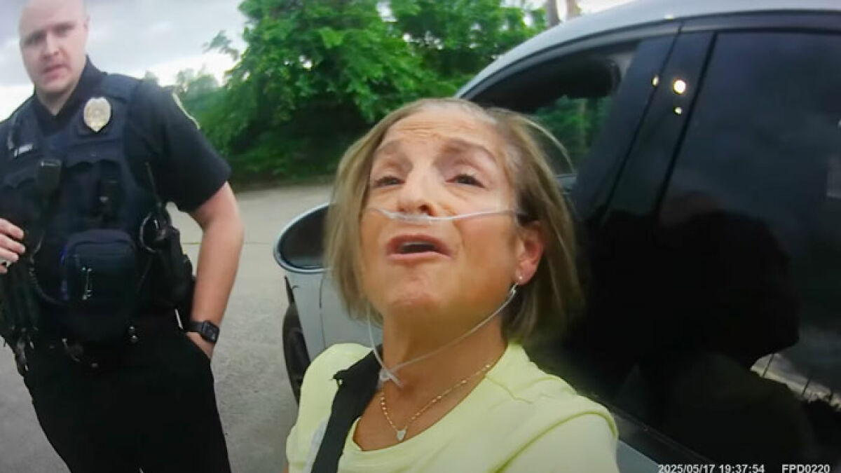 Olympic gold medalist Mary Lou Retton during arrest video outside car with police officer, failing sobriety test.