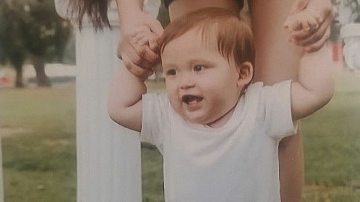 Baby held by mother outside, representing tragic loss in car incident and court case with tougher charges.