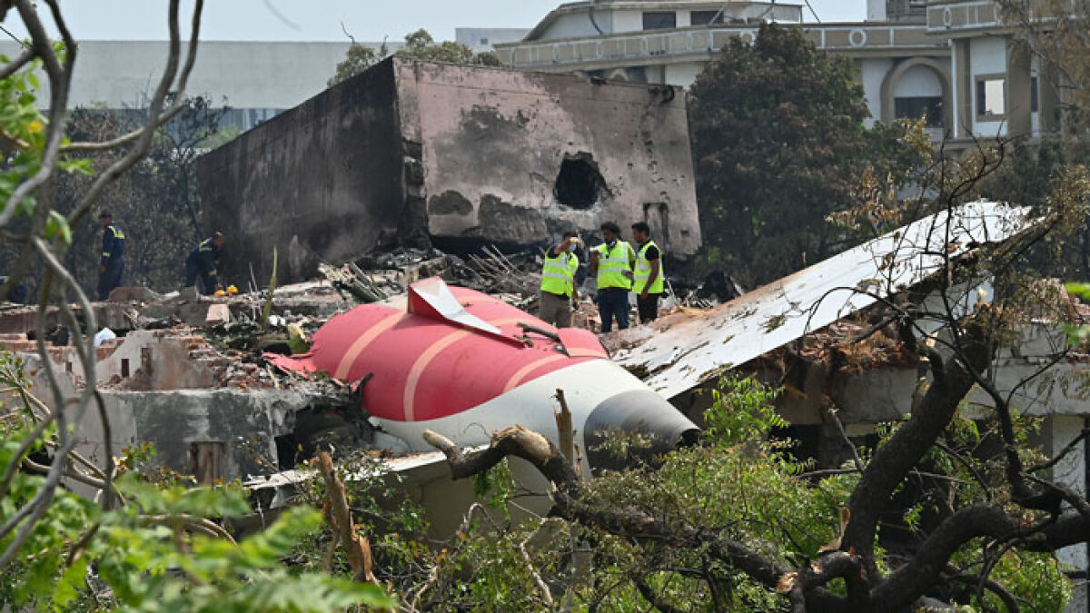 Wreckage of Air India plane crash site with investigators inspecting debris after pilot deliberately shut off fuel.