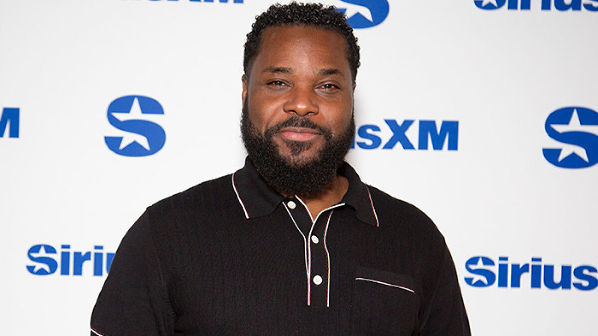 Malcolm-Jamal Warner at SiriusXM event wearing a black shirt, known for The Cosby Show, posing for the camera.