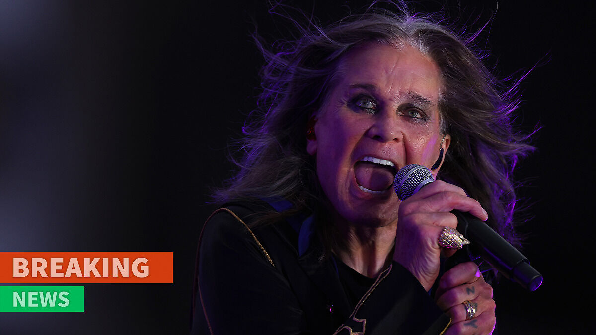 Ozzy Osbourne singing passionately into a microphone during a live performance with a dark background.