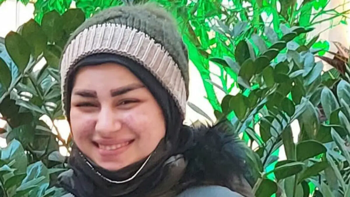Smiling young woman wearing a winter hat and jacket, surrounded by green plants, highlighting 17YO mom case public anger.
