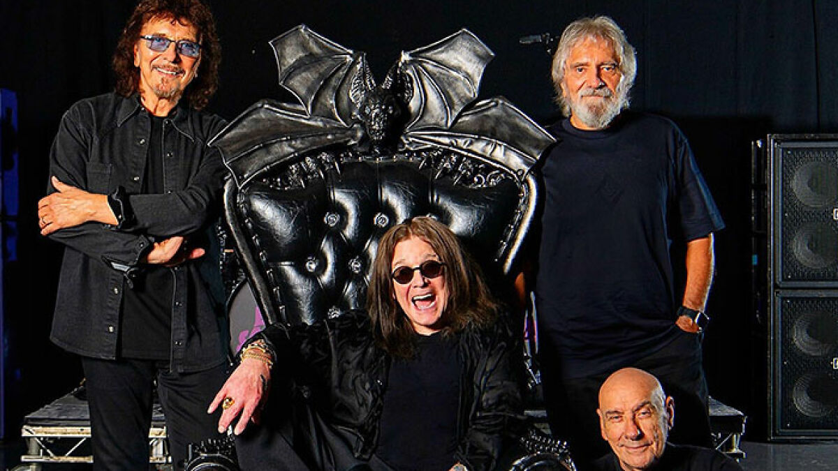 Black Sabbath band members posing around a gothic leather chair, reflecting on Ozzy's passing with emotional statements.
