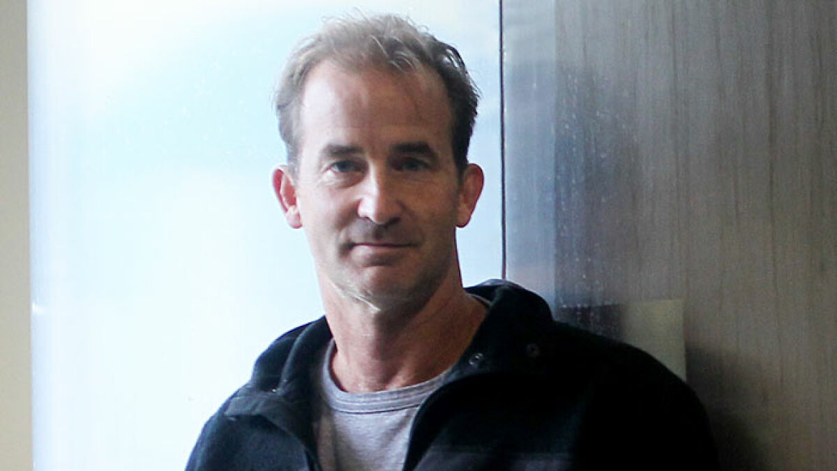 Middle-aged man in casual attire standing indoors near a window, related to Coldplay HR exec mortgage news.