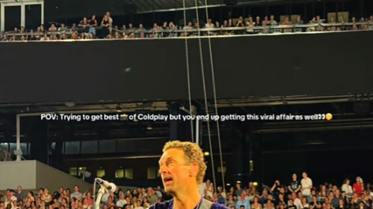 Coldplay lead singer performing on stage in front of a large crowd during a viral Coldplay couple concert moment.