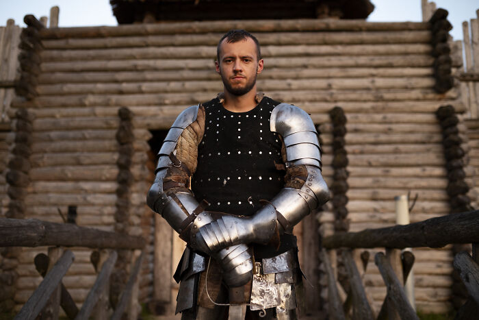 Man dressed in medieval armor standing on a wooden bridge, illustrating weird calls first responders encountered.