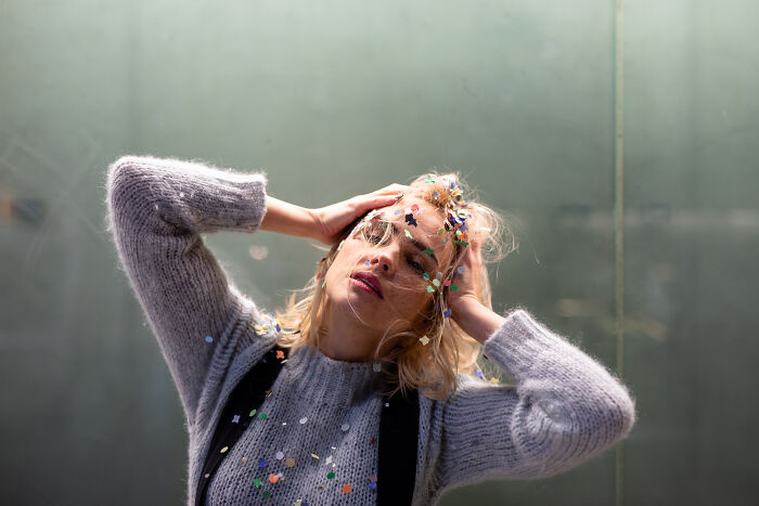 Woman with confetti on her hair and sweater, looking overwhelmed, illustrating weird calls first responders handled.
