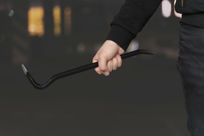 Person holding a crowbar, representing one of the weirdest calls first responders have encountered online.