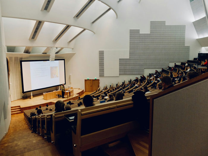 Lecture hall filled with young women attending a class as requested by a creepy professor, leaving him visibly fuming.