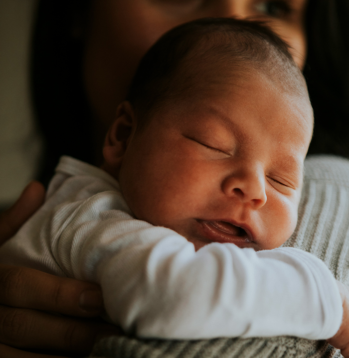 Newborn baby with dark skin peacefully sleeping in a parent's arms, highlighting daughter’s dark skin and DNA test story. Newborn baby with dark skin peacefully sleeping in a parent's arms, highlighting daughter’s dark skin and DNA test story.