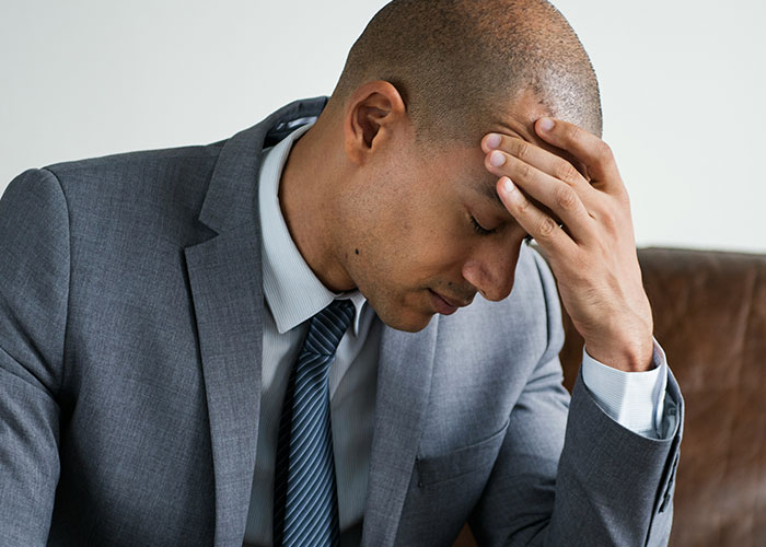 Upset man in a gray suit holding his forehead, expressing frustration related to family concerns and custody issues. Upset man in a gray suit holding his forehead, expressing frustration related to family concerns and custody issues.