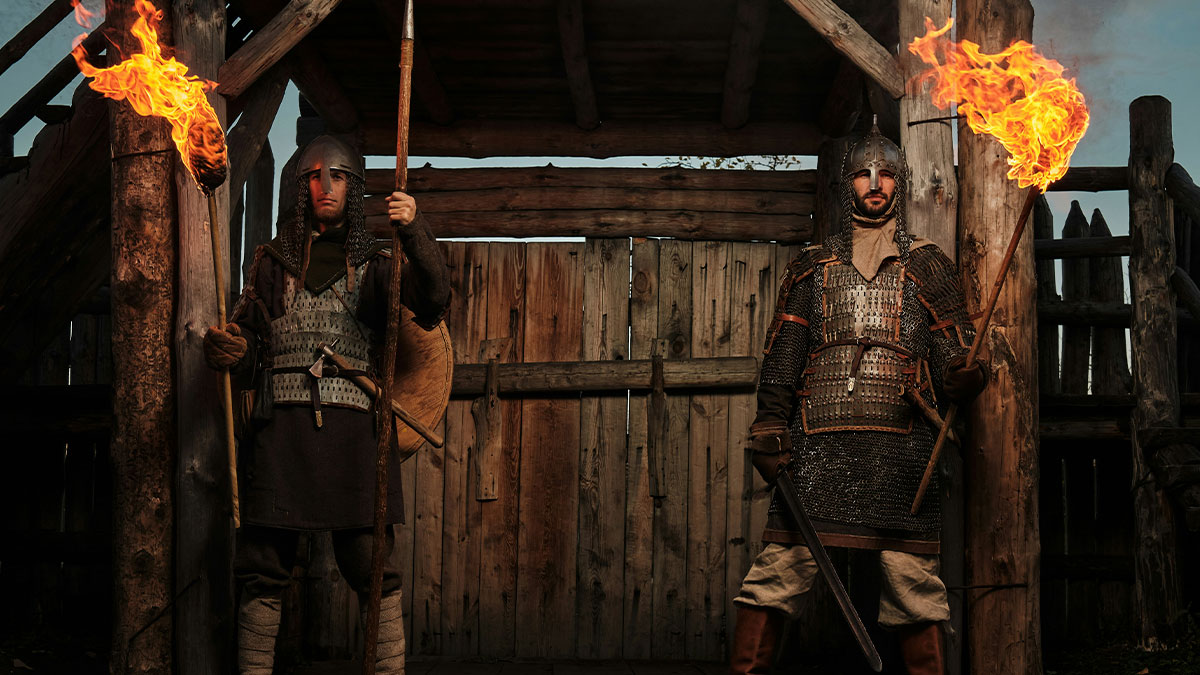 Two medieval warriors holding flaming torches in front of a wooden gate illustrating lies proven false repeatedly.