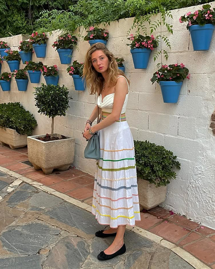 29YO student wearing a white dress standing near flower pots, casually revealing she's descendant of the last King of Mongolia. 29YO student wearing a white dress standing near flower pots, casually revealing she's descendant of the last King of Mongolia.