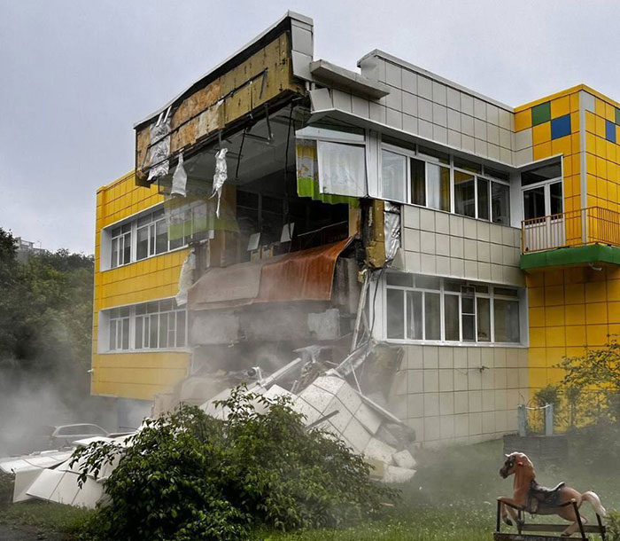 Partially collapsed building with debris and smoke, illustrating damage amid tsunami evacuation controversy involving Oprah. Partially collapsed building with debris and smoke, illustrating damage amid tsunami evacuation controversy involving Oprah.